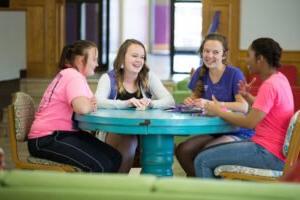 HSU students sitting at a round table talking, smiling, and laughing